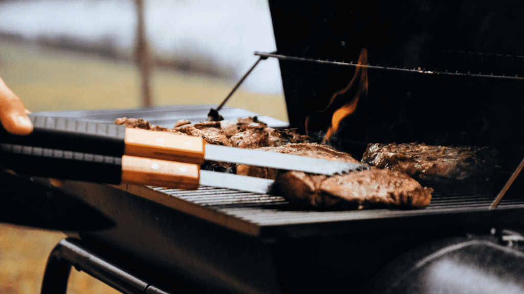 Smoking Brisket in a Grill with tongs