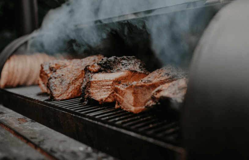 Brisket being smoked in a smoker